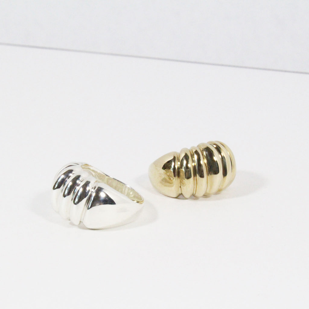 One silver and one gold dome rings with ridged texture.