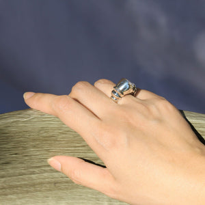 Model wearing silver ring on ring finger.