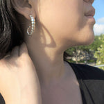 Model wearing sterling silver earring with ridged texture.