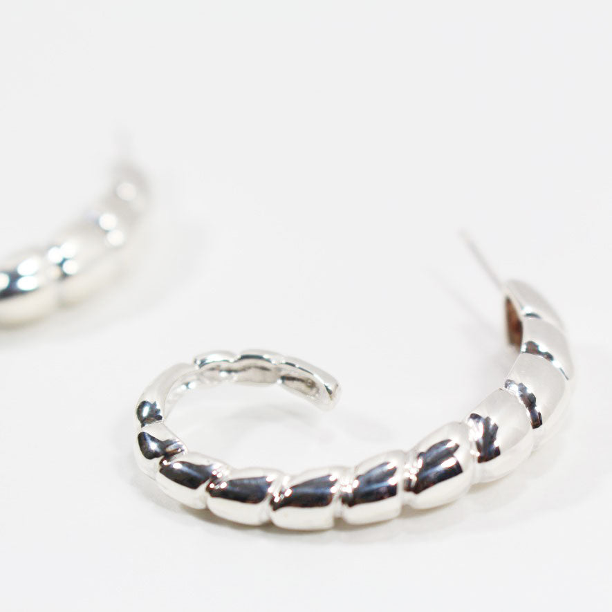 Side view of sterling silver hoop earrings with ridged texture.