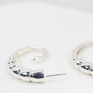 Back view of sterling silver hoop earrings with ridged texture.