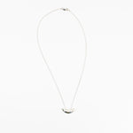 Small silver crescent shaped pendant on delicate chain necklace.
