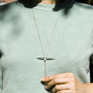 Model wearing pike shaped pendant on silver chain necklace.