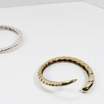 Side view of sterling silver and gold brass bracelets